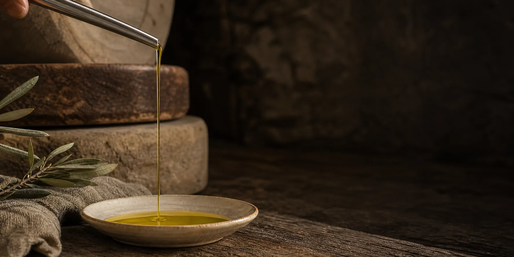 Una mano versa l'olio extravergine di oliva del frantoio